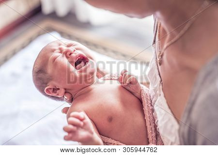 Selected Focus On Little Lovely Baby Girl Crying While Mother Try To Wear Her A Blanket And Clothes.