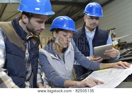 Industrial engineers meeting in mechanical factory