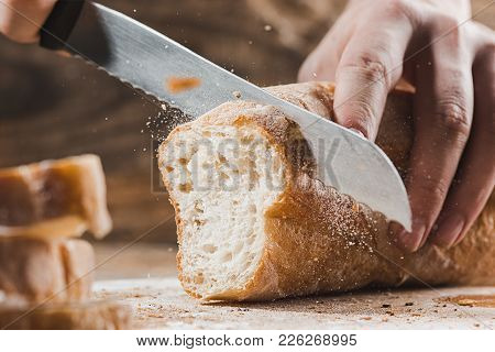 Whole Grain Bread Put On Kitchen Wood Plate With A Chef Holding Gold Knife For Cut. Fresh Bread On T