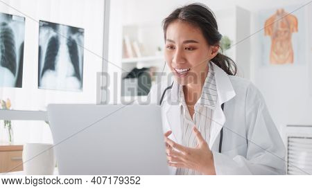 Asian Female Doctor Using Laptop Computer Online Video Call Remote Talking To Patient, Prescribe Med