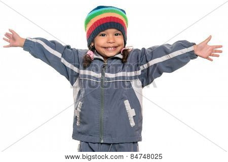 Happy mixed race little girl wearing a colorful beanie hat offering a hug with wide open arms isolated on white