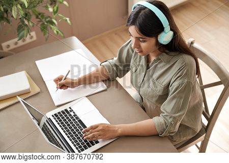 Indian Girl Student Wear Headphones Learning Online Watching Webinar Class Looking At Laptop Compute