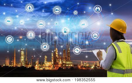 Industry 4.0 concept engineering use clipboard with checking and industrial icons on oil refinery industry sunset background.