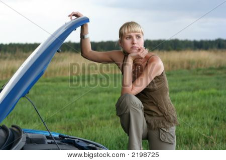 Young Blond Woman With Her Broken Car. The Girl Is Sad