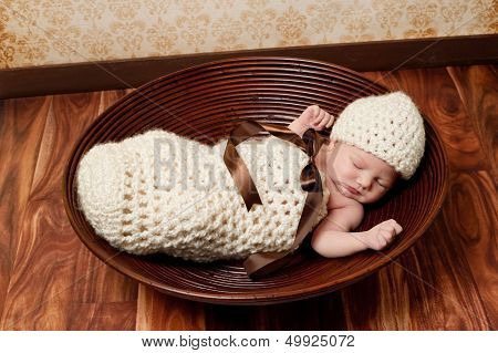 Newborn Baby Girl Sleeping In A Brown Bowl